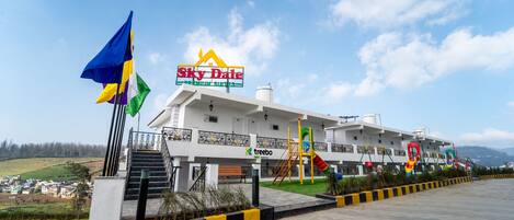 A hotel with a sign for 'Sky Dale Premium Suites' and a playground area.