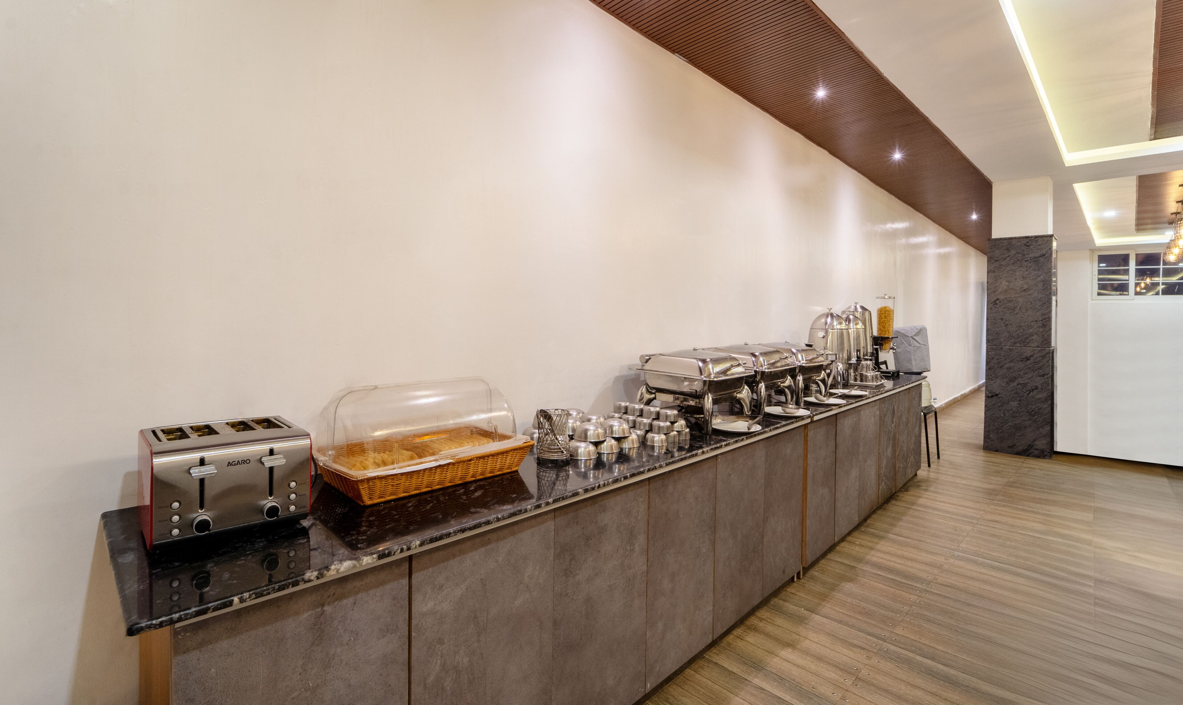 A breakfast bar with a toaster, a wicker basket, and various food dispensers.