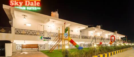 A hotel named Sky Dale with a sign indicating premium suites. It features a playground with slides and a bench.
