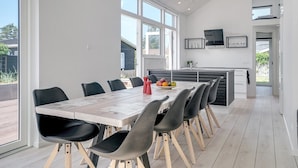 Een moderne keuken met een eethoek, grote ramen en uitzicht op het omliggende landschap.