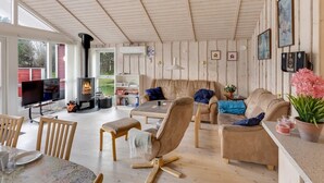 Ein gemütliches Wohnzimmer mit Kamin, bequemen Sitzgelegenheiten und einem Fernseher.