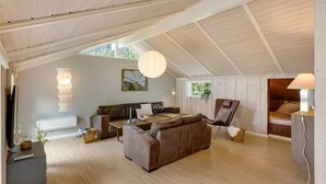 Ein geräumiges Loft mit hohen Decken, einem großen Sofa, einem Sessel, einem Bett und einem Essbereich.