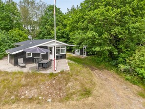 A small, modern house with a patio, a dining area, and a garage.