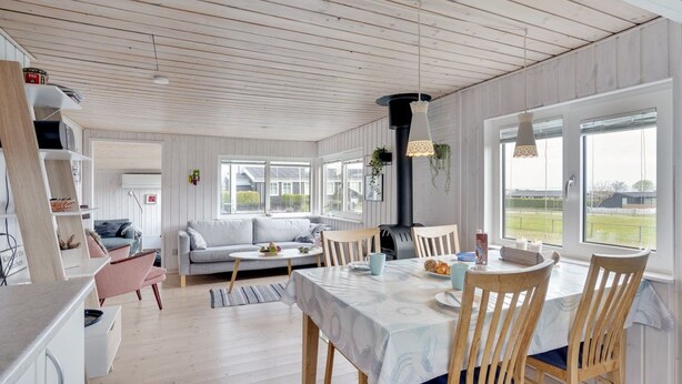 Een ruime keuken met houten kastjes, een eethoek met een tafel en stoelen, en een gezellige zithoek met een bank en salontafel.