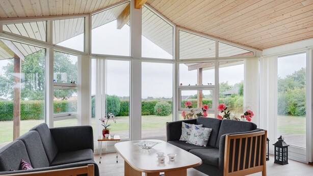 A spacious room with a high ceiling and large windows, a sofa, a coffee table, and a wooden floor. - "Kimi" - 800m from the sea by Interhome (Glesborg)
