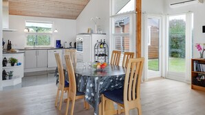 A modern kitchen with a dining area, wooden ceiling, and large windows. - "Kimi" - 800m from the sea by Interhome (Glesborg)