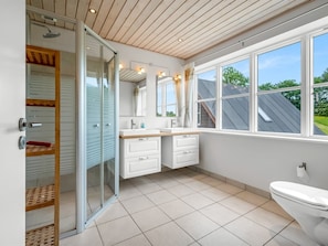 Et moderne badeværelse med bruser, toilet og vaskemøbel.