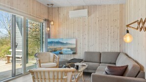 Een moderne woonkamer met een bank, fauteuil en een glazen salontafel.
