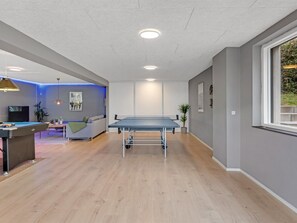 Une pièce équipée d’une table de ping-pong, d’un canapé, d’un téléviseur et d’une table de billard.