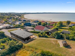 Une zone résidentielle côtière comprenant des maisons, une étendue d’eau importante et une jetée.