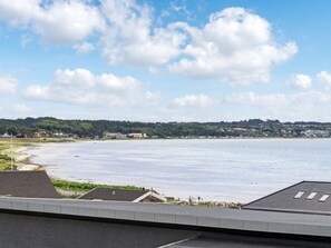 A coastal view with a clear sky, a sandy beach, and a distant forested area. - "Ahmik" - 200m from the sea by Interhome (Ebeltoft)