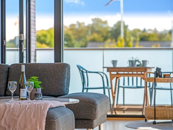 A balcony with a table set for two, a bottle of Riesling wine, and two glasses.