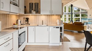 Una cucina moderna con mobili bianchi, una macchina da caffè e un'ampia finestra con vista panoramica.