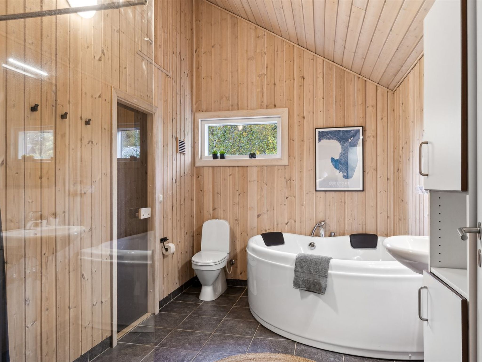 Un baño moderno con una bañera independiente, un inodoro y una ducha con cerramiento de vidrio.