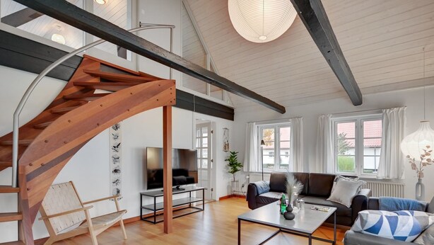 A spacious living area with a wooden staircase, a sofa set, a coffee table, and a TV. - "Malinda" - 500m from the sea by Interhome (Odder)