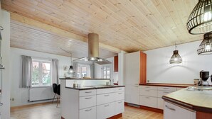 A modern kitchen with wooden flooring, white cabinetry, and pendant lighting. - "Malinda" - 500m from the sea by Interhome (Odder)