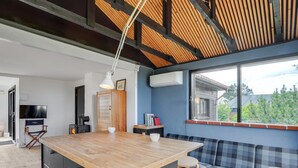 Una cocina moderna con una isla de madera, una estufa negra y un televisor en la pared.