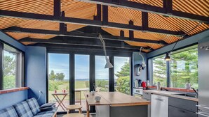 Una cocina moderna con una isla grande, taburetes de bar y vistas al exterior.