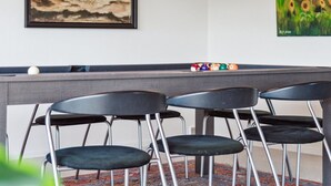 A pool table with four chairs, two pendant lights, and two framed artworks on the wall. - "Ingward" - 750m from the sea by Interhome (Vestervig)