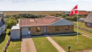 A single-story building with a tiled roof, a flagpole with a flag, and a well-maintained lawn. - "Ingward" - 750m from the sea by Interhome (Vestervig)