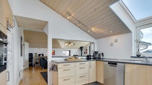Une cuisine moderne avec des meubles en bois, un îlot central et une grande fenêtre.