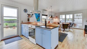 A spacious kitchen with a central island, a large window, and a view of the outdoors. - "Thamara" - 350m from the sea by Interhome (Harboøre)