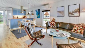 A modern living room with a sofa, coffee table, and a dining area with a table and chairs. - "Thamara" - 350m from the sea by Interhome (Harboøre)