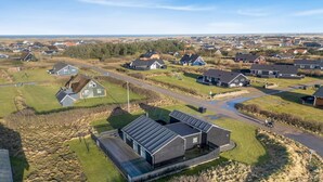 Vista aérea de una zona residencial con casas, calles y espacios verdes.