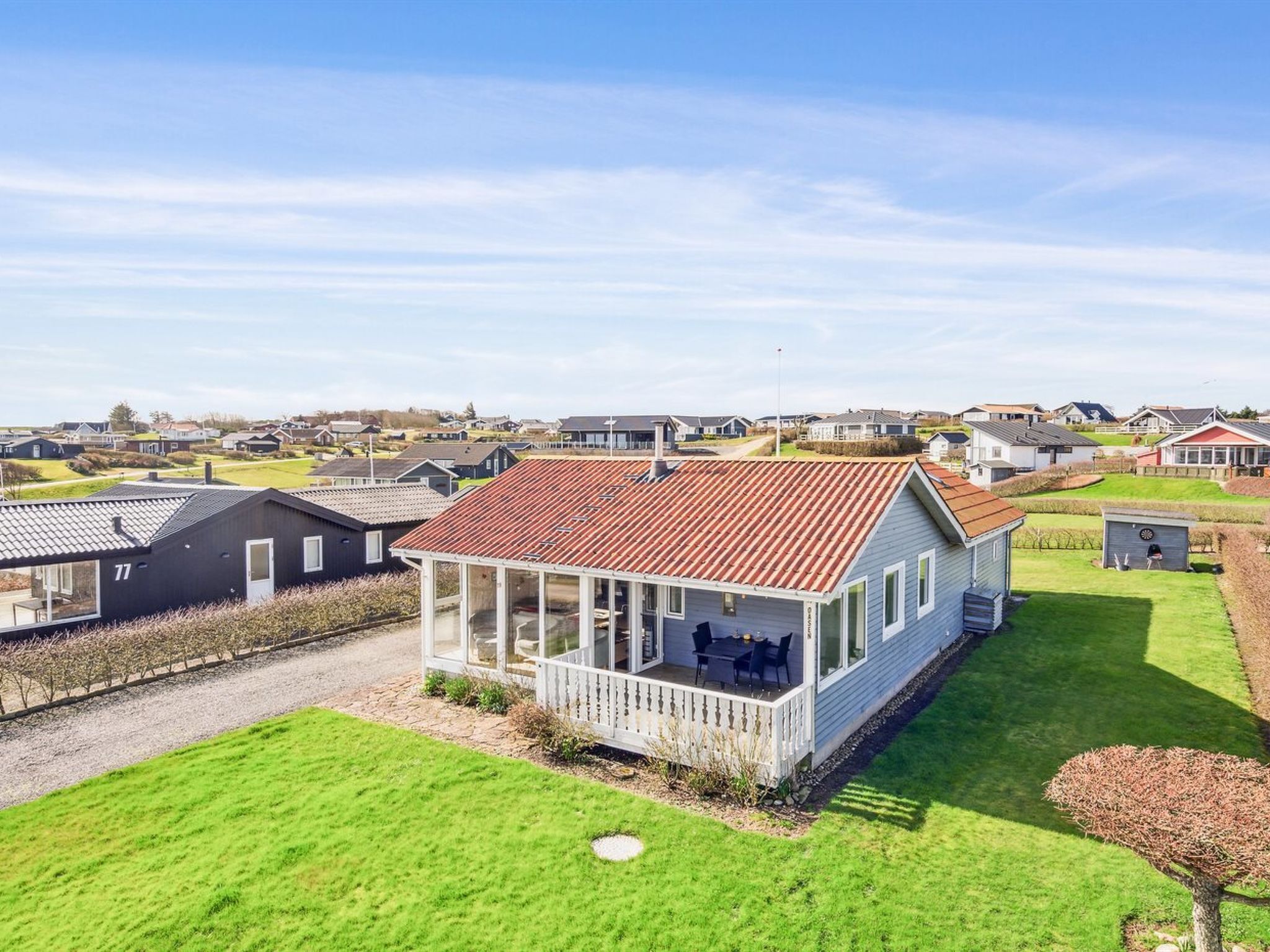 Een woonwijk met huizen, een gazon en een heldere lucht.