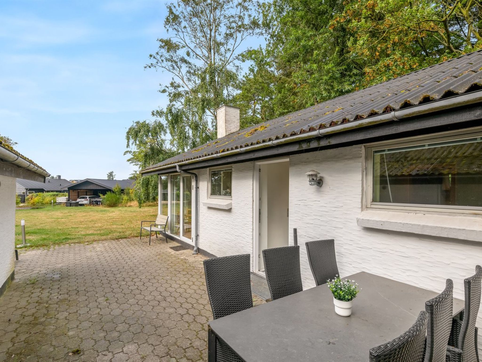 A house with a patio area, outdoor seating, and a view of the surrounding landscape.