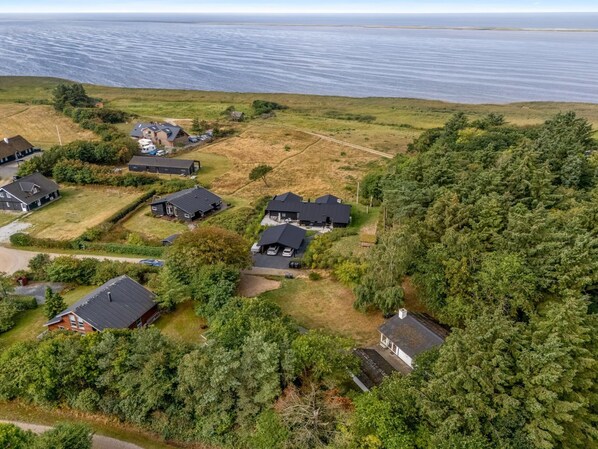 Zona residencial con casas rodeadas de vegetación y vistas al mar.