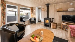 Una sala de estar acogedora con chimenea, televisor y comedor con frutero.