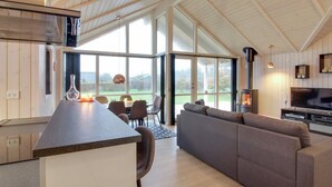 A modern kitchen with a large island, a dining area with a table and chairs, a living room with a sofa, and a fireplace. - "Gertrude" - 1.1km to the fjord by Interhome (Hemmet)