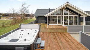 A modern house with a hot tub on a wooden deck, large windows, and a garage. - "Gertrude" - 1.1km to the fjord by Interhome (Hemmet)
