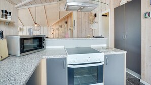 Une cuisine compacte équipée d’un four à micro-ondes, d’une cuisinière et d’un four traditionnel.