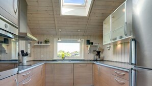 A modern kitchen with wooden cabinets, stainless steel appliances, and a skylight. - "Eicke" - 12km from the sea by Interhome (Oksbøl)