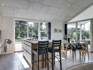 A modern kitchen with a central island, large windows, and a dining area with wooden chairs. - "Stacey" - 800m from the sea by Interhome (Oksbøl)