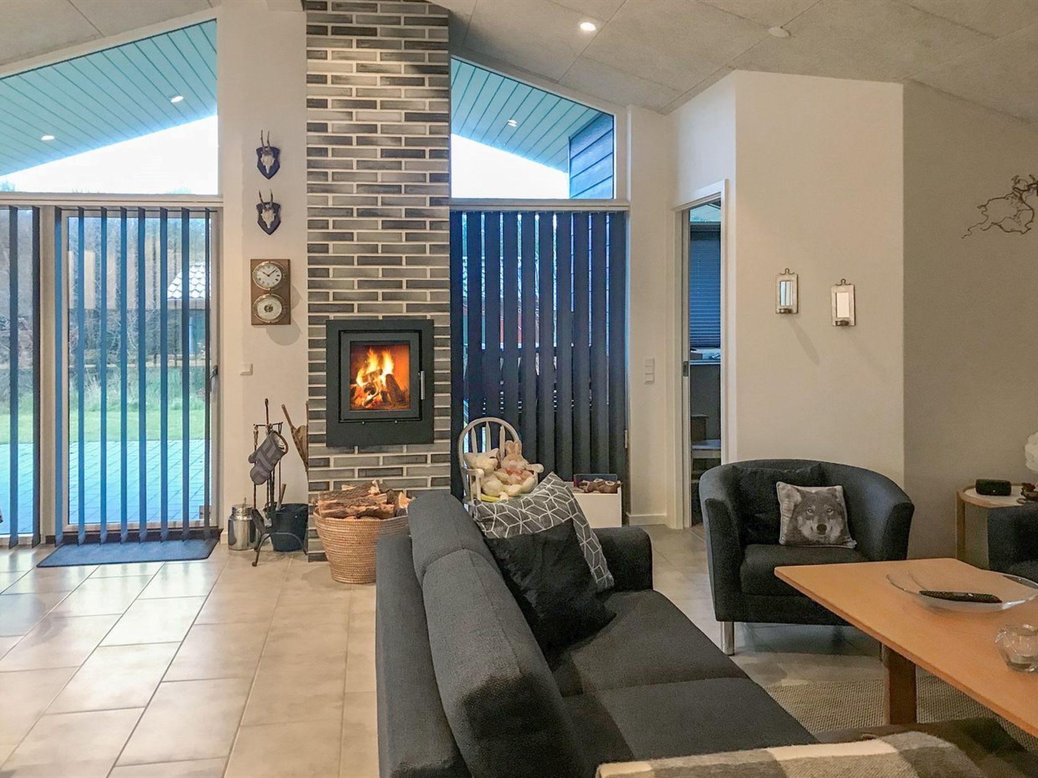 Un salon moderne avec une cheminée, un canapé, une table basse et une table à manger.
