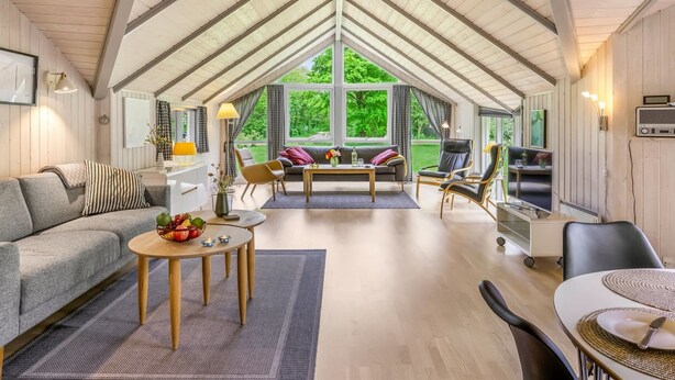 Un loft spacieux avec de hauts plafonds, de grandes fenêtres, un coin salon confortable et une kitchenette.
