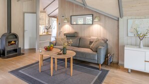 Une pièce confortable avec un canapé, une petite table, une cheminée et un buffet.