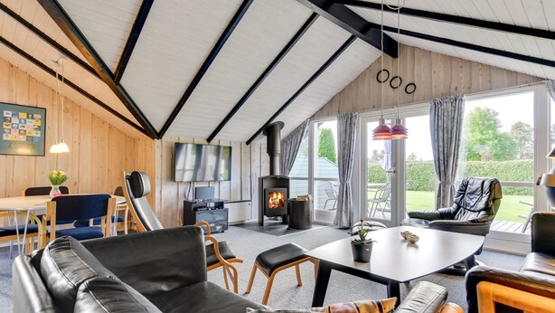 A modern living room with a fireplace, leather sofa, dining area, and large windows. - "Joona" - 600m from the sea by Interhome (Sydals)