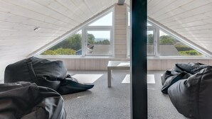 Habitación de áticos con techos altos, tejado inclinado, ventanas amplias y vistas al paisaje.