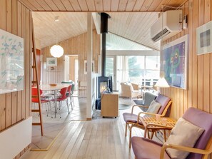 Un vaste espace de vie doté d’une cheminée, de planchers en bois et de meubles modernes.