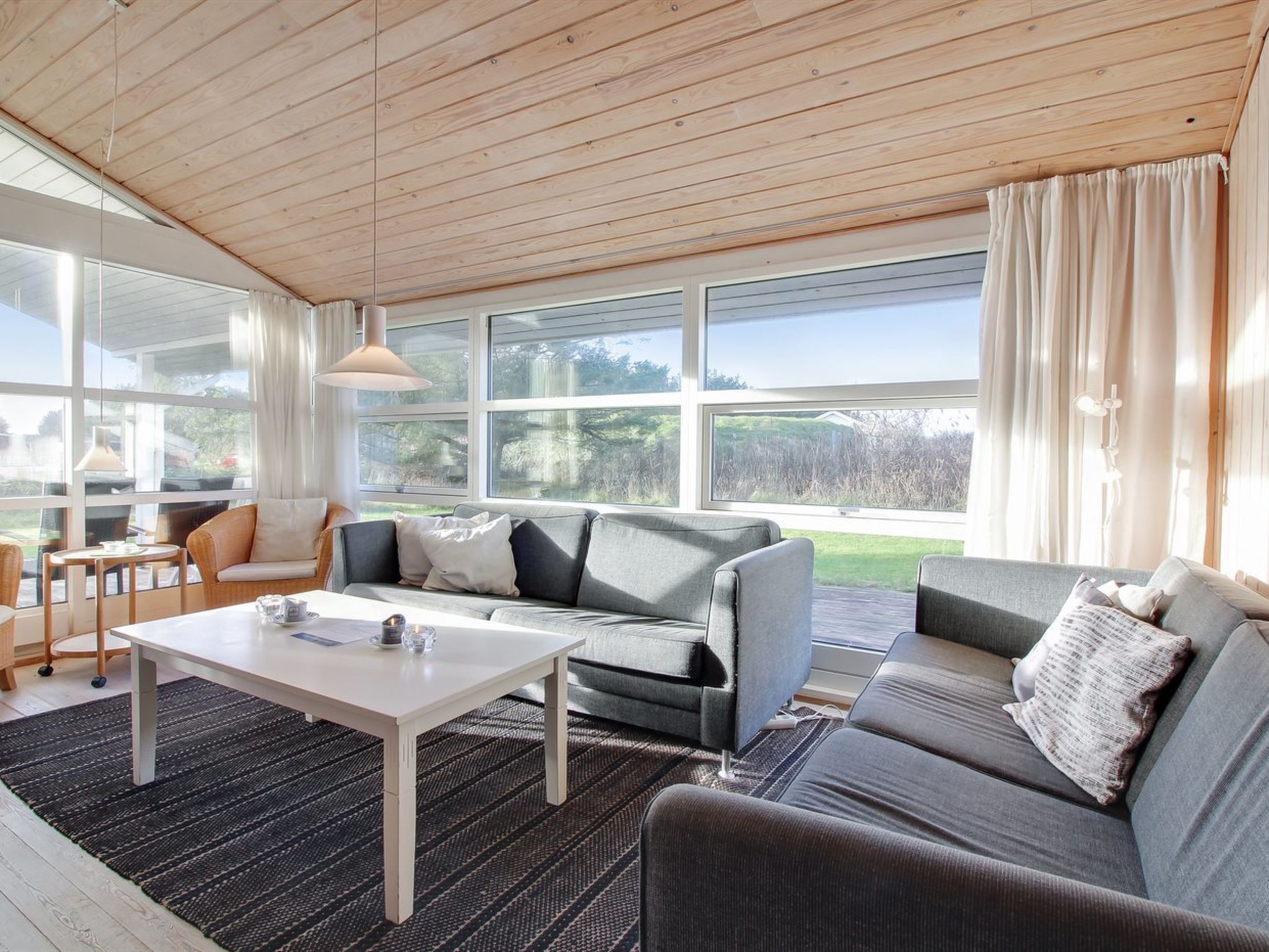 Ein modernes Wohnzimmer mit einer Couch, einem Couchtisch und einem Essbereich mit Stühlen.
