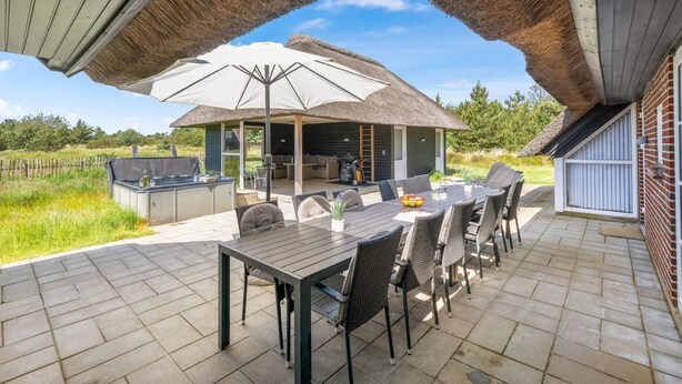 An outdoor patio with a dining table, chairs, a grill, and a large umbrella. - "Vangel" - 500m from the sea by Interhome (Blåvand)