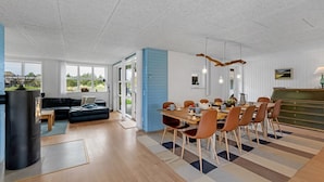 A modern living space with a dining area, a sofa, and a fireplace. - "Vangel" - 500m from the sea by Interhome (Blåvand)