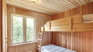 A wooden cabin room with a bunk bed, a window with a view of greenery, and a ceiling fan. - "Jaane" - 650m to the fjord by Interhome (Hemmet)