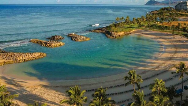 A coastal resort with a beach, palm trees, and a view of the ocean. - Dream of Aloha (Kapolei)
