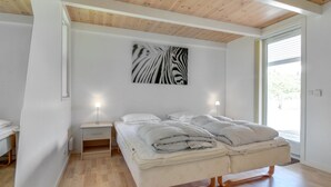 A bedroom with a bed, bedside tables, a zebra print artwork, and a window with blinds. - "Villads" - 1km from the sea by Interhome (Løkken)