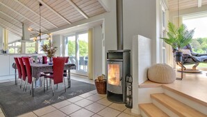 A modern kitchen with a dining area, a fireplace, and a staircase leading to an upper level. - "Villads" - 1km from the sea by Interhome (Løkken)